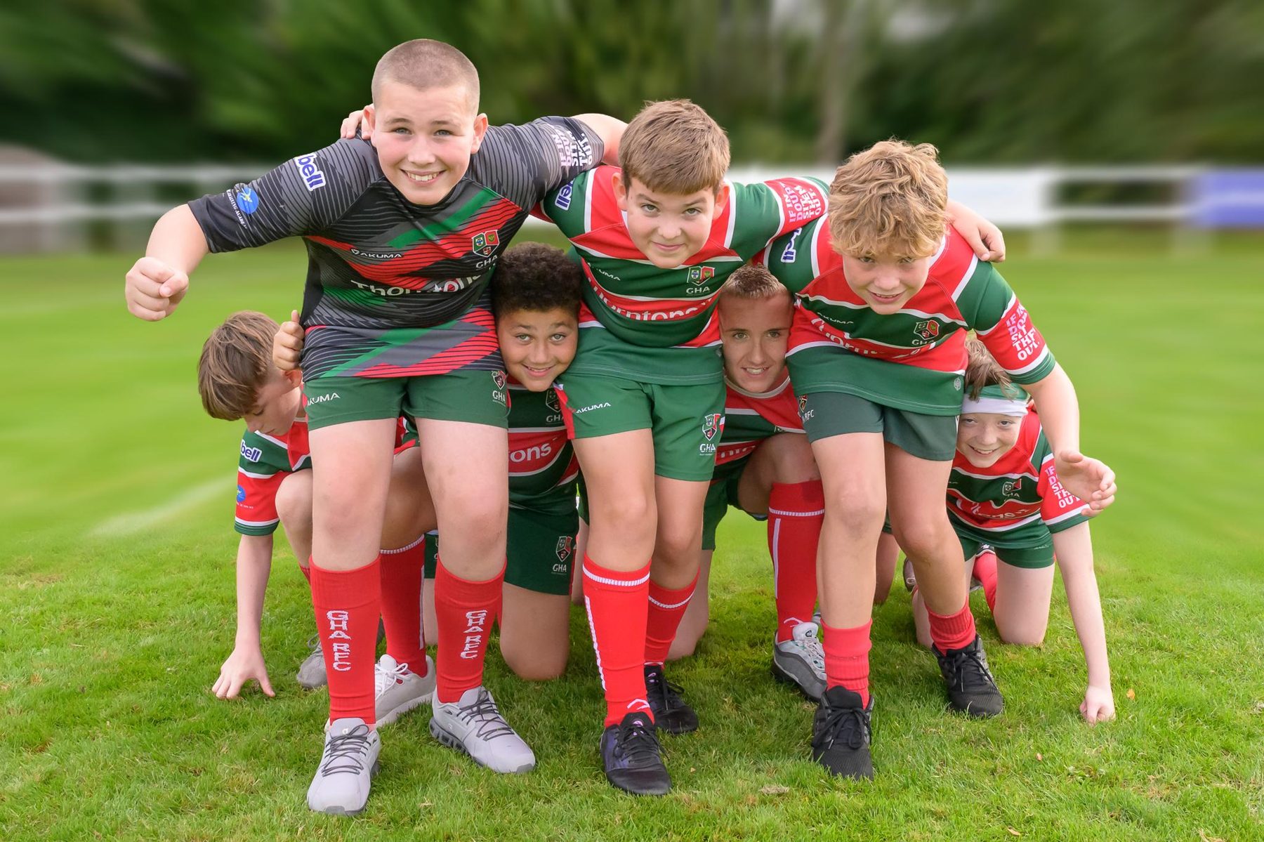 GHA Rugby minis players celebrating together in club kit on the pitch